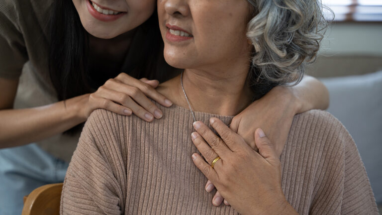 wanita tua sedang dirangkul oleh seorang wanita dari belakang
