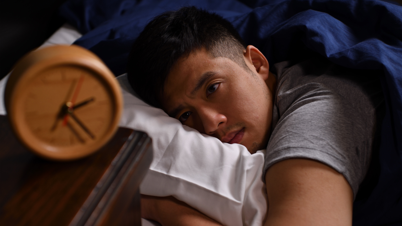 Man lying awake at night and struggling to sleep